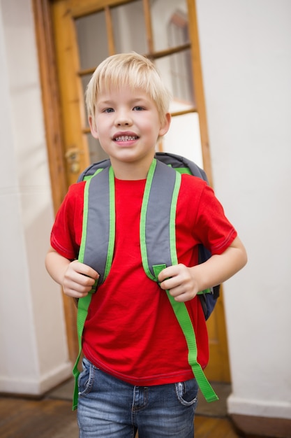 Cute pupil smiling at camera in classroom