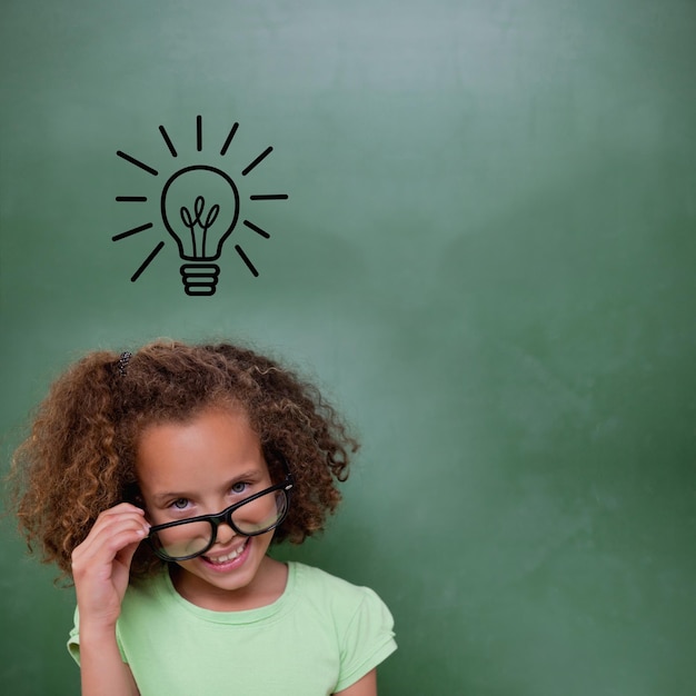 Photo cute pupil tilting glasses against idea and innovation graphic