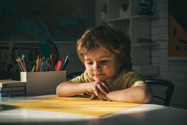 変な顔の学校の仕事でかわいい生徒黒板の机の近くの教室でかわいい子供の男の子幸せなsch