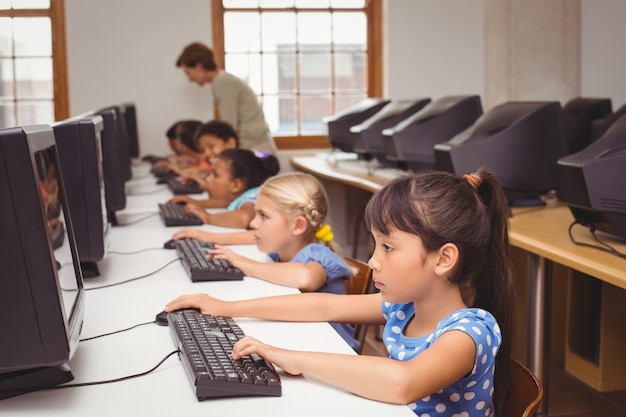 Cute pupils in computer class with teacher