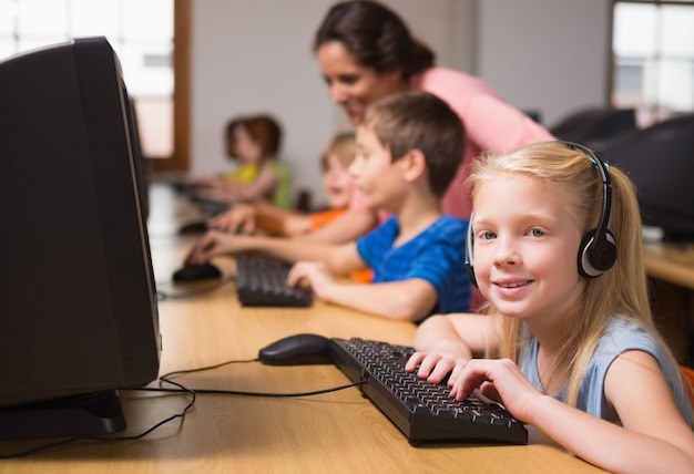 Cute pupils in computer class with teacher