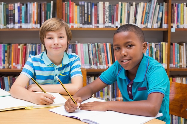 Cute pupils drawing in library 