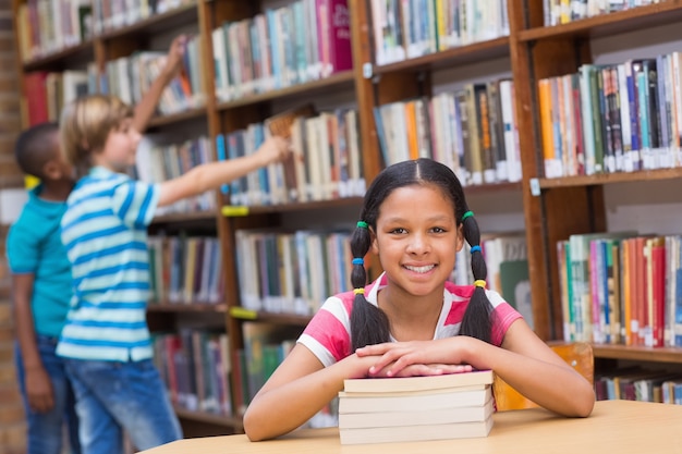 Cute pupils looking for books in library 