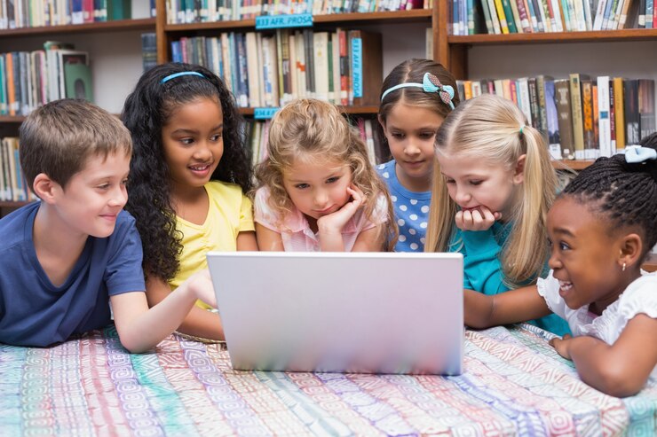 Photo cute pupils looking at laptop in library