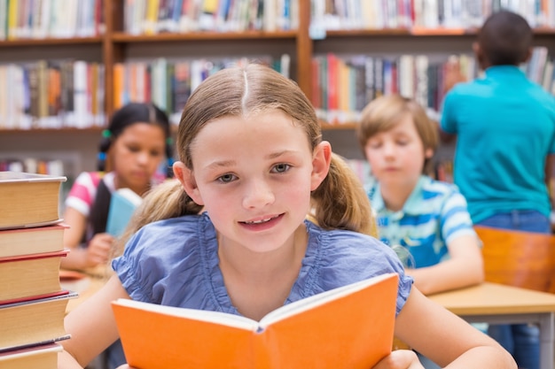 Cute pupils reading in library