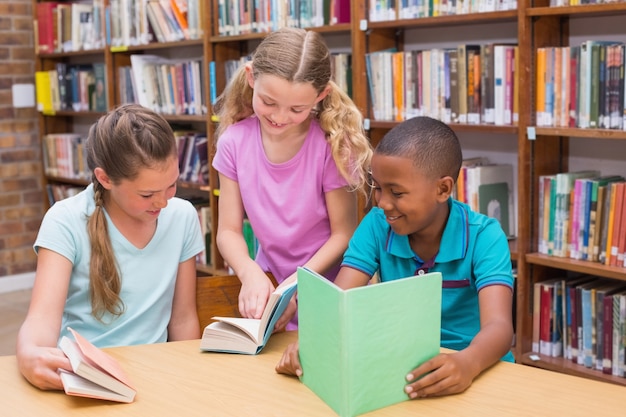 Cute pupils reading in library 