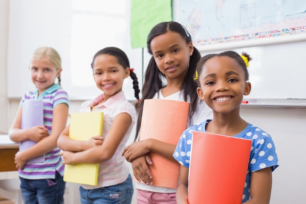 Cute pupils smiling at camera during class presentation 