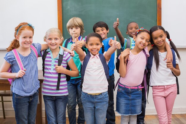 Foto allievi svegli che sorridono alla macchina fotografica in aula