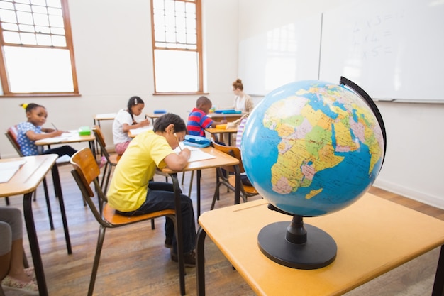 Foto carino alunni e insegnante in aula con il globo