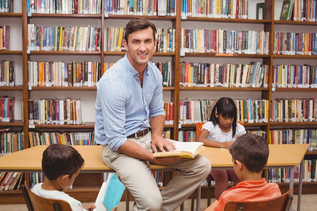 Cute pupils and teacher having class in library