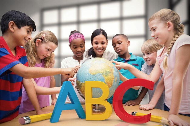 Cute pupils and teacher looking at globe in library  against room with large window showing city