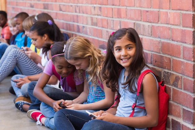 Cute pupils using mobile phone