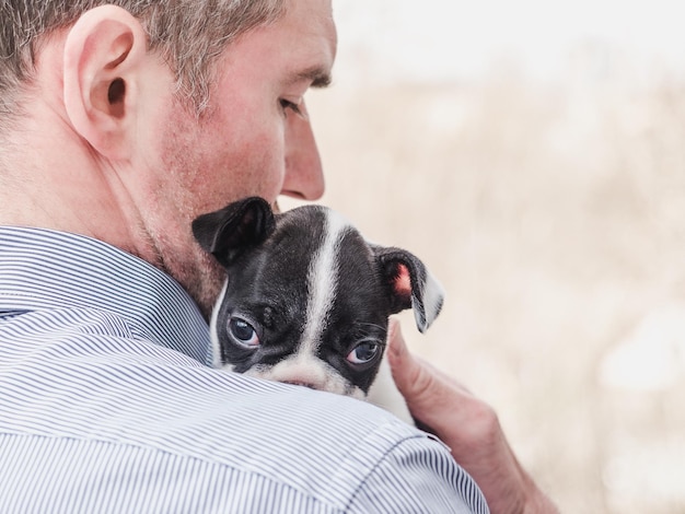 Cute puppy lying on a man's shoulder