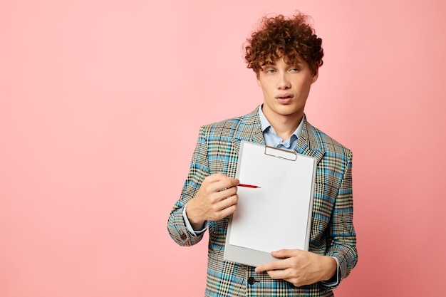 Cute redhaired guy in a business suit copyspace documents pink background unaltered