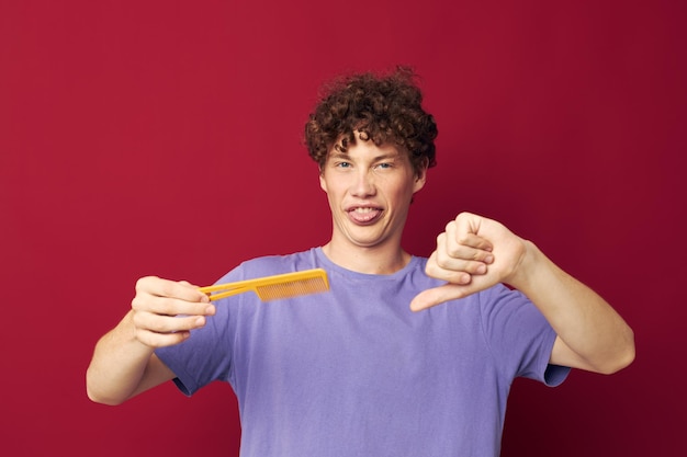 Carino ragazzo dai capelli rossi pettine per la cura dei capelli in posa sfondo isolato