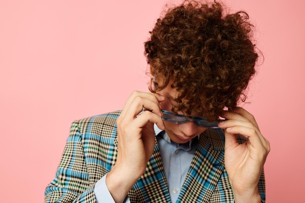 Cute redhaired guy folder for papers blank sheet posing in suit pink background unaltered