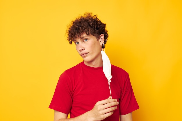 Cute redhaired guy in a red tshirt medical mask protection isolated background unaltered