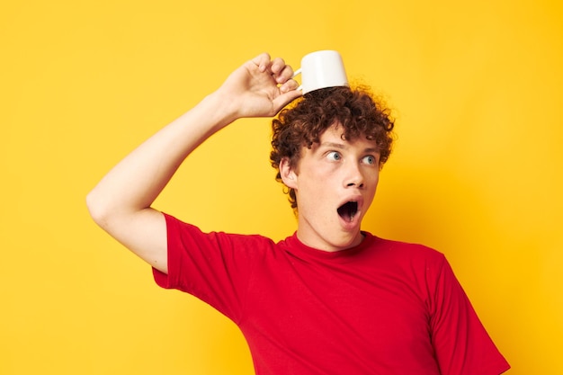 Cute redhaired guy in a red Tshirt with a white cap in his hands isolated background unaltered