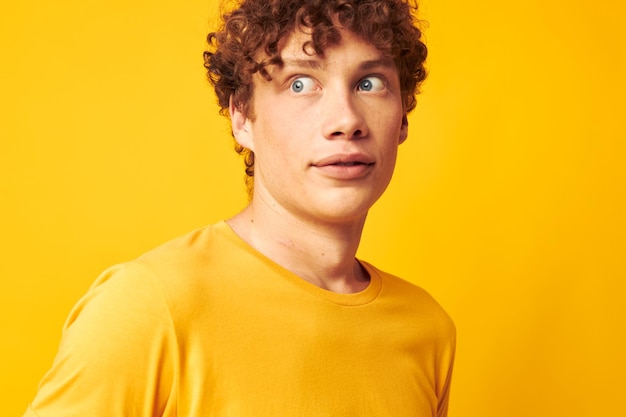 Cute redhaired guy wearing stylish glasses yellow tshirt posing yellow background unaltered