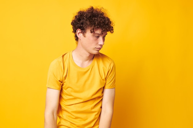 Симпатичный рыжеволосый парень в стильной желтой футболке позирует на изолированном фоне без изменений