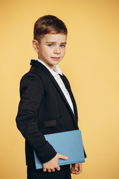 Cute school boy wearing school uniform and holding books