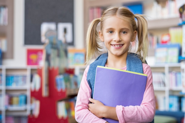 Cute school girl holding book