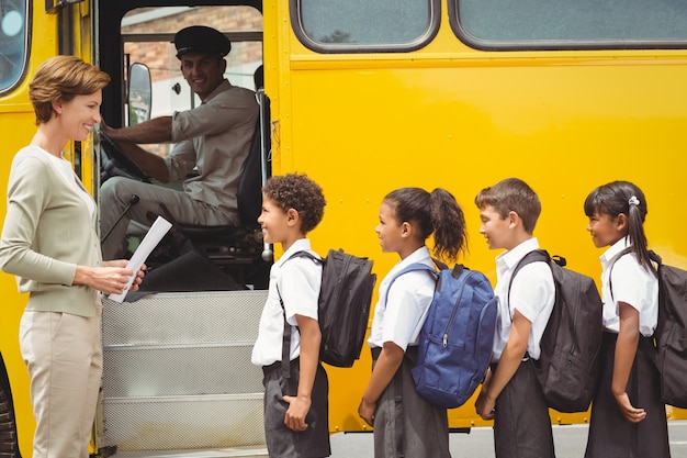 Cute schoolchildren waiting to get on school bus