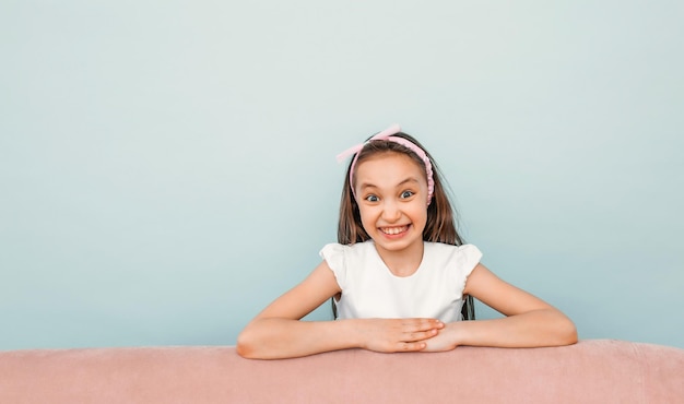 Foto primo piano sorridente della ragazza sveglia della studentessa su una priorità bassa blu