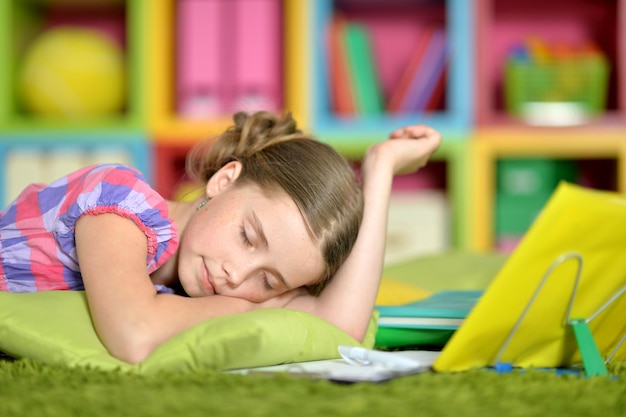 Cute schoolgirl sleeping at her homework at home