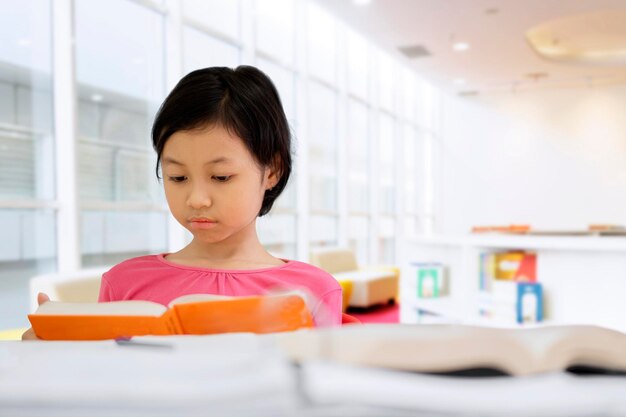 Photo cute schoolgirl studying with a book