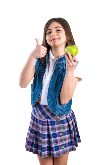 Cute schoolgirl with apple on white