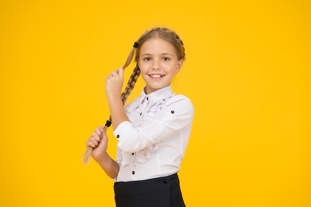 Cute schoolgirl with long hair Graduation concept Primary education Perfect schoolgirl Welcome back to school Small schoolgirl with happy smile Little schoolgirl looking nice in school uniform