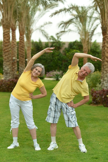 Photo cute senior couple exercising in summer park