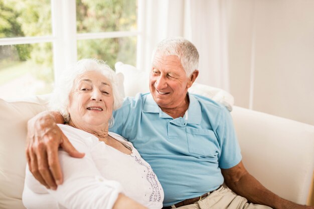 Cute senior couple hugging on sofa