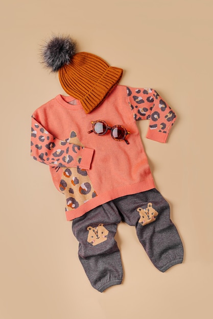 Cute set of autumn childrens outfit. Leopard print sweater and cotton pants. Fall mood