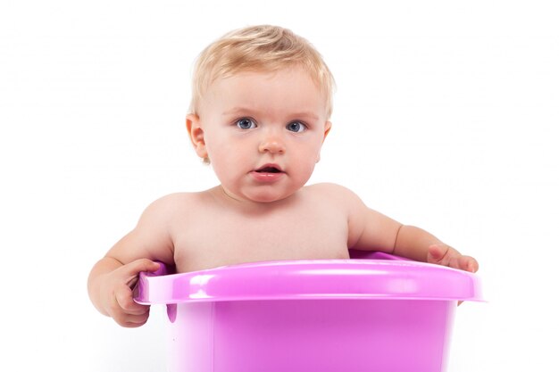 Cute shy little boy in purple tub