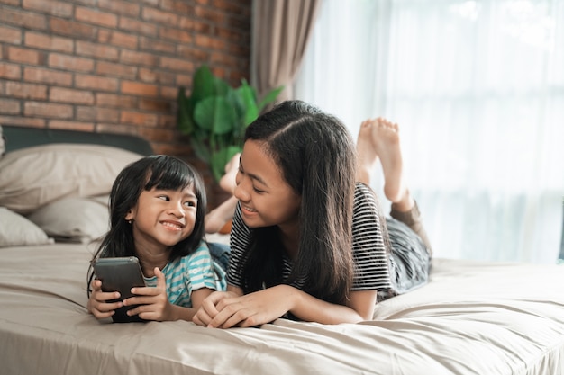 Cute sibling using mobile phone together