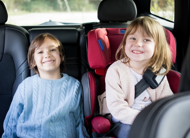 Cute siblings on backseat in car