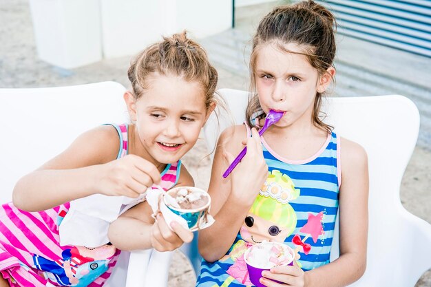 Photo cute siblings eating ice cream at home