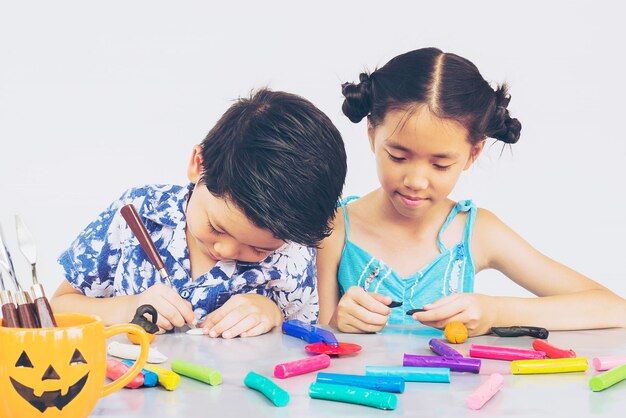 Cute siblings playing on table on gray background