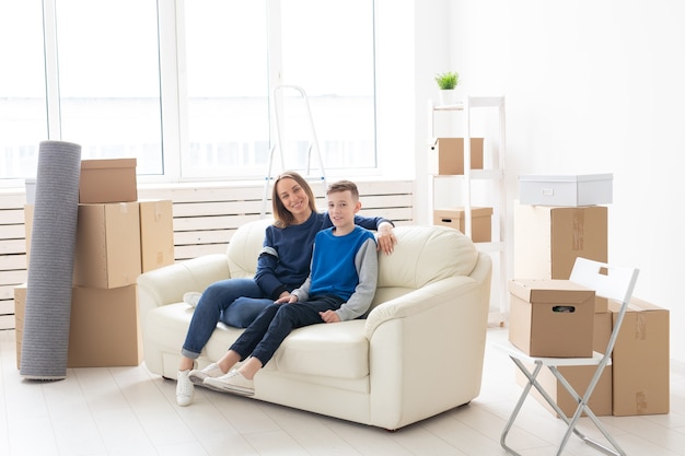Cute single mom and little boy son relaxing after the move. The concept of housewarming mortgage and the joy of new housing.