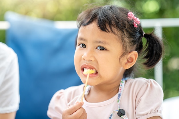 かわいい小さな女の子は、屋外でランチにフライドポテトを食べることをお楽しみください