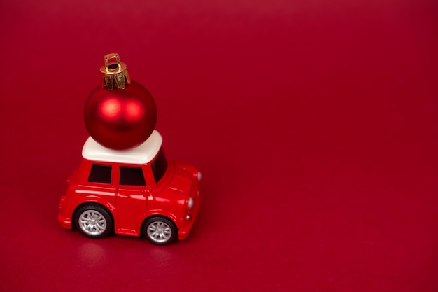 Cute small red automobile with red christmas ball
