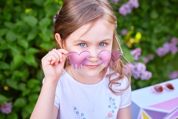 Cute smiling baby girl 35 year old long hair posing outdoors over nature background Looking at camera Spring season Childhood