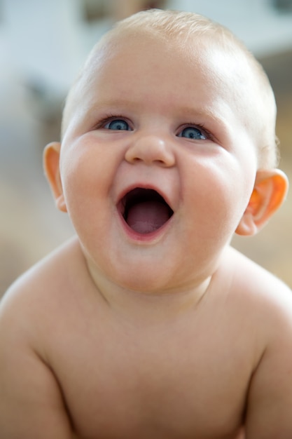 Cute smiling baby sitting at home.