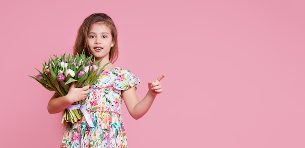 Cute smiling child girl holding bouquet of spring flowers