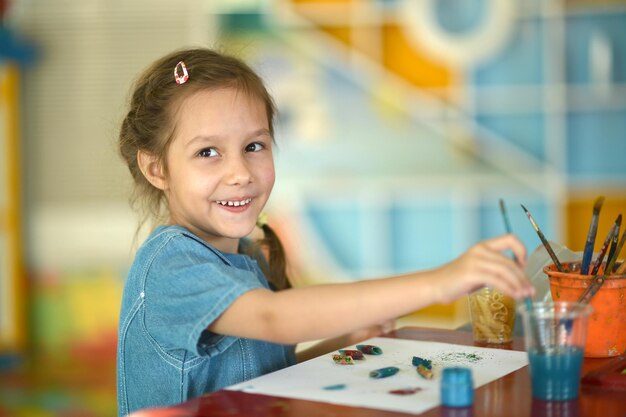 Cute smiling girl drawing at home