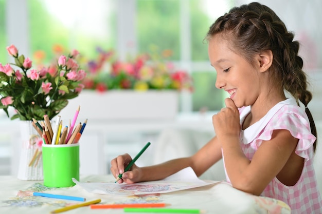 Cute smiling girl drawing at home