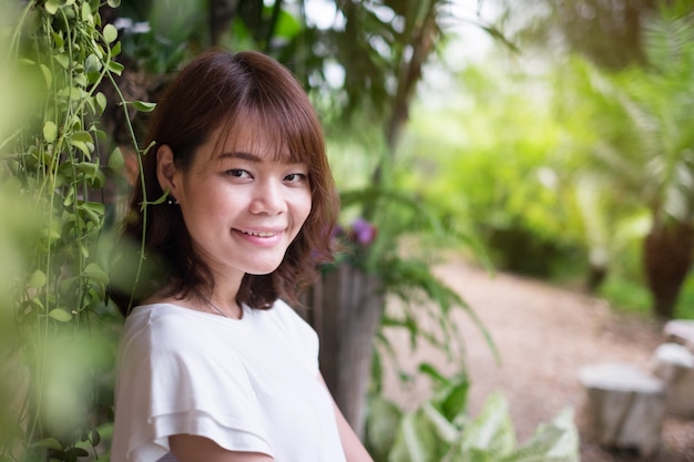 Cute smiling girl looking at you with nature background at park