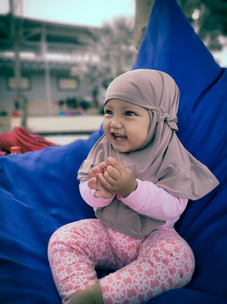 Cute smiling girl sitting outdoors